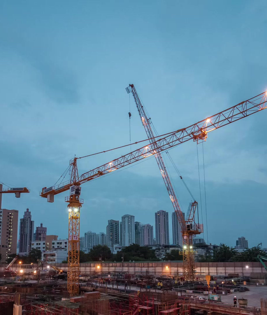 Gru e strutture di un cantiere urbano al tramonto